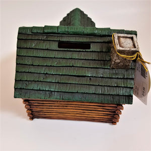 Back of cabin bank--bottom has a log look. Top has a green thatched roof with a faux-stone chimney on the right and the slot for coins in the center.