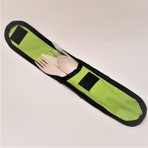 Open green pouch revealing a wooden fork, knife, spoon, metal straw with plastic top and bristle brush of straw cleaner.