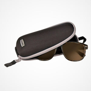 Open black sunglass case with gray zipper trim and sunglasses popping out of the unzipped case.
