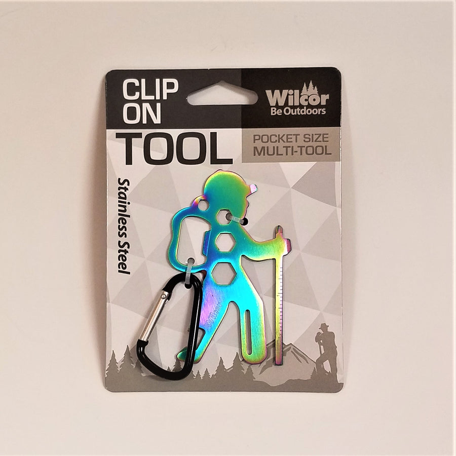 Clip-on Hiker Tool in packaging. Stainless steel hiker appears in shades of blue, green with a hint of yellow. The vertical hiker stands to the right of the black and silver carabiner clip.