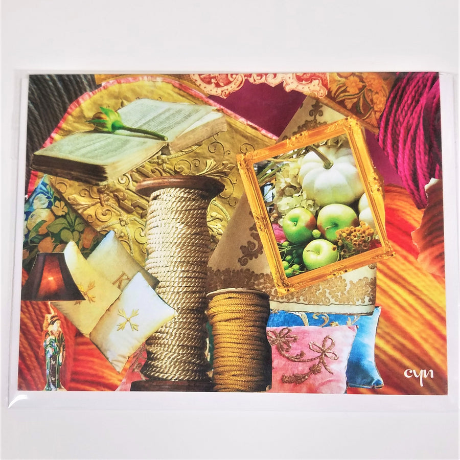 Front of collage card with various colorful fabrics and images: top left: open old book with rose in middle; Pumpkin and apples in a gold frame; Pink and blue decorative pillows; two spools of gold cord in different sizes, 4 more decorative pillows; an Asian woman lamp stand.