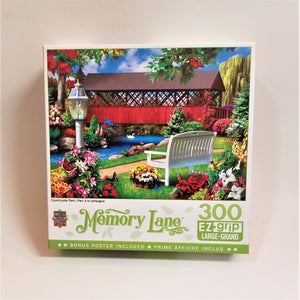 Box cover for 300 piece EZ grip puzzle. Features red covered bridge in a bucolic pastoral setting with a white bench, flowers, lamp post, and swan on the very blue water.