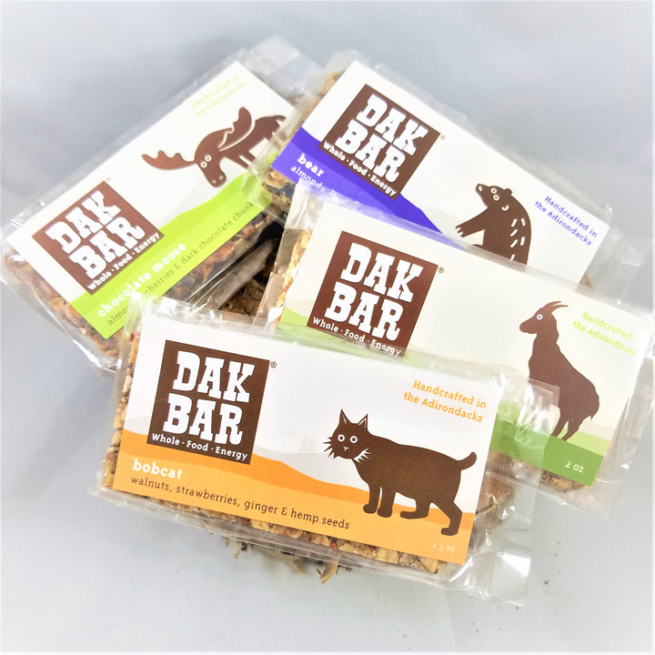 Pile of Dak bars . Visible are the Moose on the Chocolate Moose, the Bear on the almond, wild blueberries & maple; the Goat on the Green Goat, green apple, maple & walnut; and the Bobcat on the walnuts, strawberries and seeds
