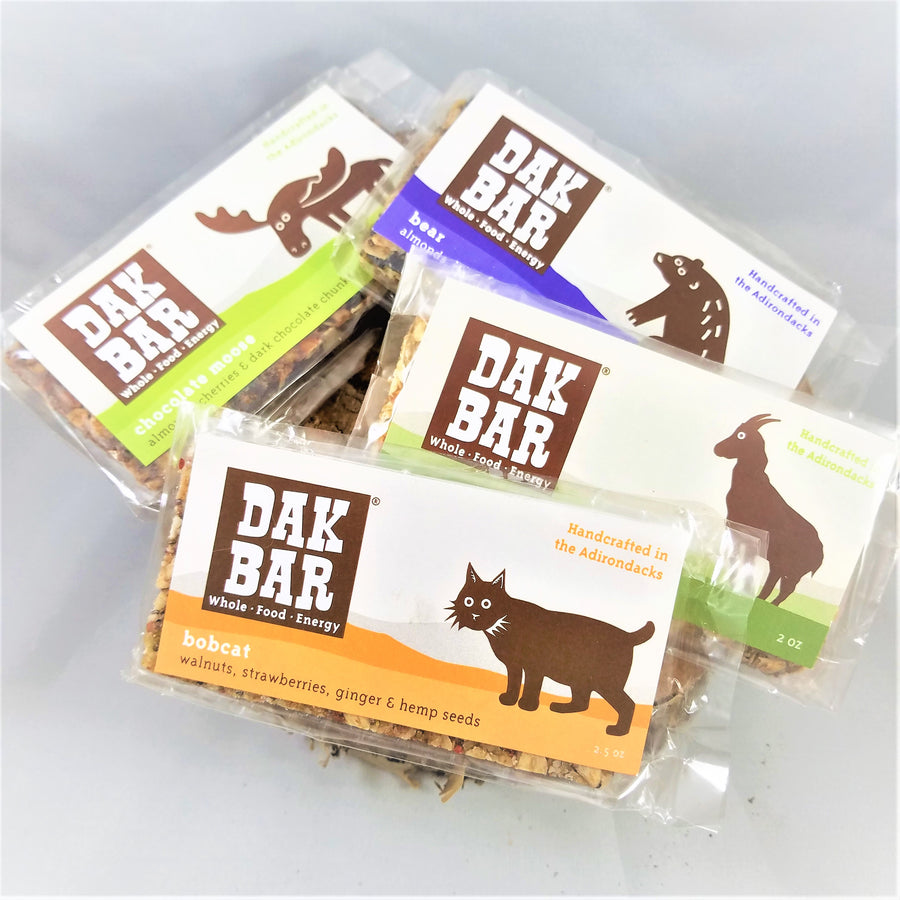 Pile of Dak bars . Visible are the Moose on the Chocolate Moose, the Bear on the almond, wild blueberries & maple; the Goat on the Green Goat, green apple, maple & walnut; and the Bobcat on the walnuts, strawberries and seeds