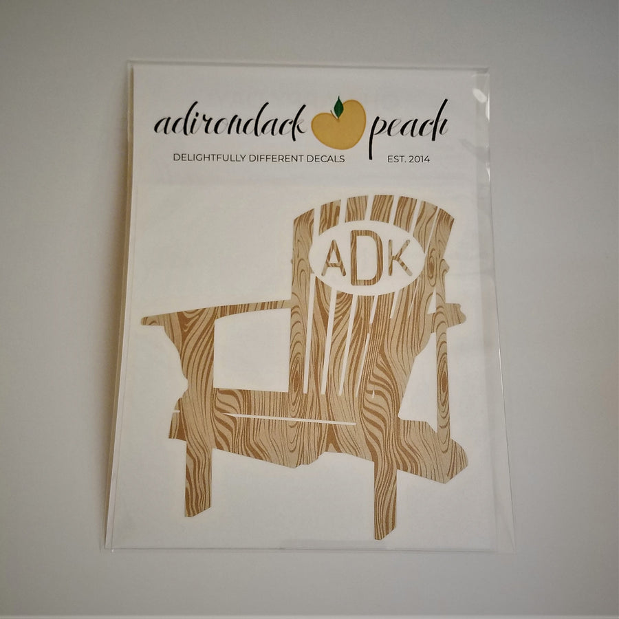 Decal of Adirondack chair in wood grain pattern with white oval and matching wood grain lettering ADK on chair back.