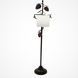 Upright pine cone toilet paper holder standing on a white background. Two pine cones are on the stand above the toilet paper with one pine cone positioned on a branch below the roll of toilet paper. 