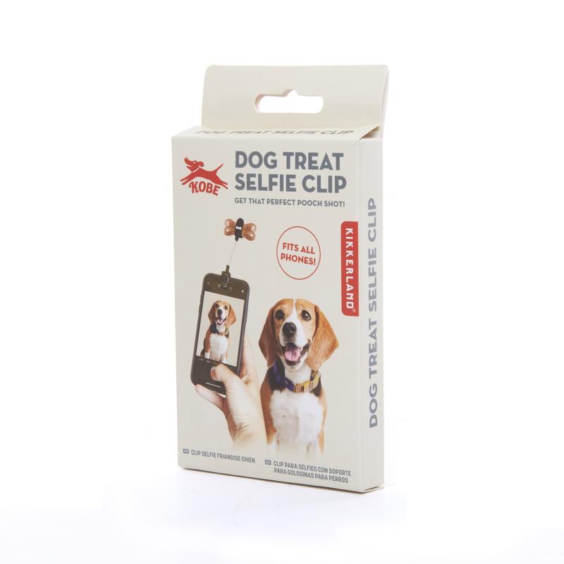 Dog Treat Selfie Clip in white packaging box with beagle looking hungrily at the treat held above the phone.