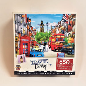 Box cover of 550 piece jigsaw puzzle featuring a busy London street with red double decker buses, cars, a red telephone both with clock tower in the background.