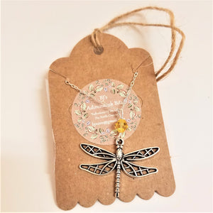 Metal  dragonfly necklace with gold glass on a silver chain on the beige packaging card from BJ's Adirondack BIts