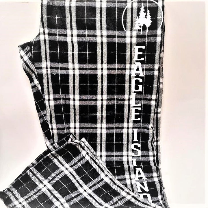 Black and white plaid pants folded with white Eagle Island logo printed over the white letters of EAGLE ISLAND--each letter set one by one vertically on the pants. 