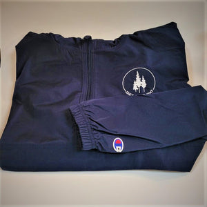 Blue windbreaker folded to show front zipper and white Eagle Island logo embroidered on top. Sleeve is folded in so red, white and blue logo is also showing.