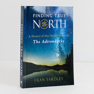 Front of paperback book Finding True North depicting an Adirondack blue gold sky and night fall on mountains and water.