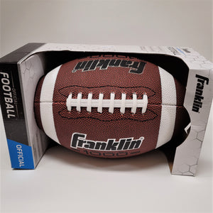 Football sitting horizontally in its cardboard packaging. The word FRANKLIN is printed in black type with white outline on teh bottom and upside down on the top. There is a white band on either side of the white lacing in the middle.