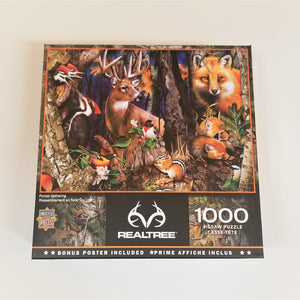 Cover of box of 1000-piece puzzle depicting a variety of forest animals and birds in a wooded setting. Lots of browns, black and evening sky poking through.