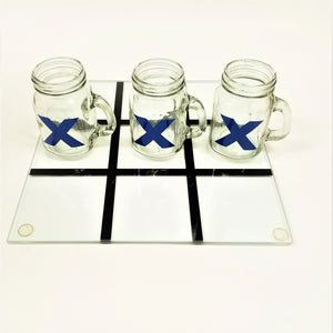 3 blue X-painted glasses lined up 3 in a row on the glass playing board