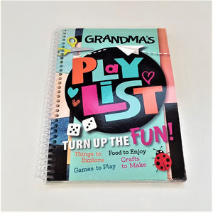 Cover of Grandma's PlayList book lying flat with clear spiral binding seen to the left. The cover features scissors dice and a red spotted lady bug.