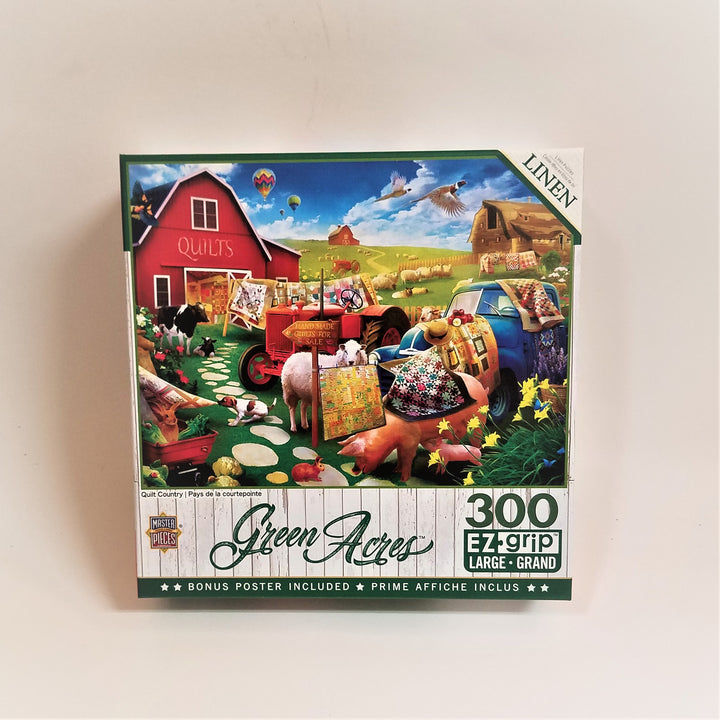 Box of 300 piece EX grip jigsaw title Green Acres. Top of box features a red Quilt barn, with two other barns in the background. Several hot air balloons and birds in the sky, farm animals, quilts and a truck on the green lawn with daffodils and haybales.