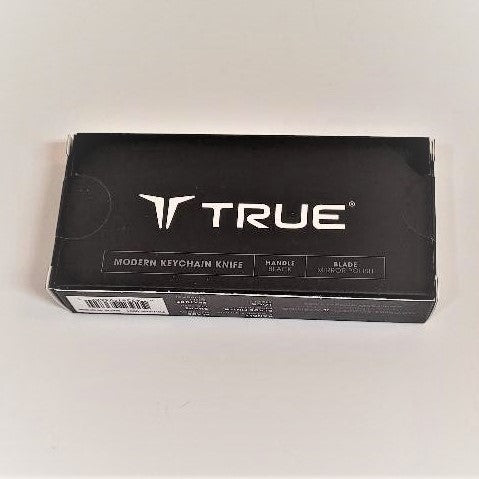 Packaging box for Keychain Knife. Black with white type that says TRUE large in center and black triangle top right.