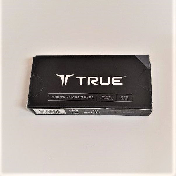 Packaging box for Keychain Knife. Black with white type that says TRUE large in center and charcoal triangle top right.
