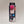 Hot pink toy puff seen through the clear window of the black box it is packaged in. Bottom of box has an illustration of a black and white cat looking at the fuzz ball while a hand holds the phone that it is attached to. White text on black type over the illustration to the left. A blue circle with the words: Fits All Phones! is above the cat.