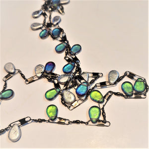 Close up of the lanyard chain with the blue ad green-pear shapes featured on the metal fishing lures.