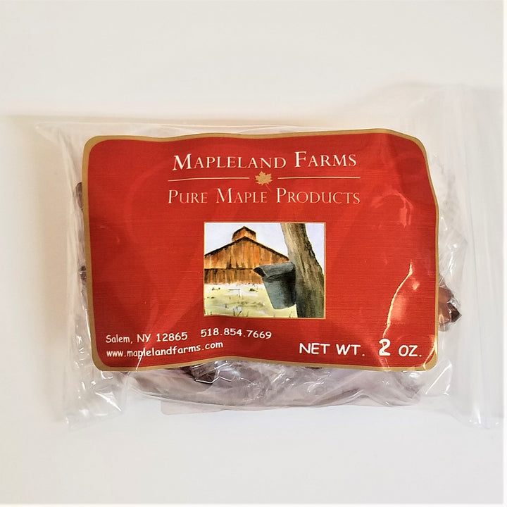 Package with large Mapleland Farms label taking up most of the front with tiny pieces of maple hard candy peeking out from the sides and the bottom of the clear packaging.