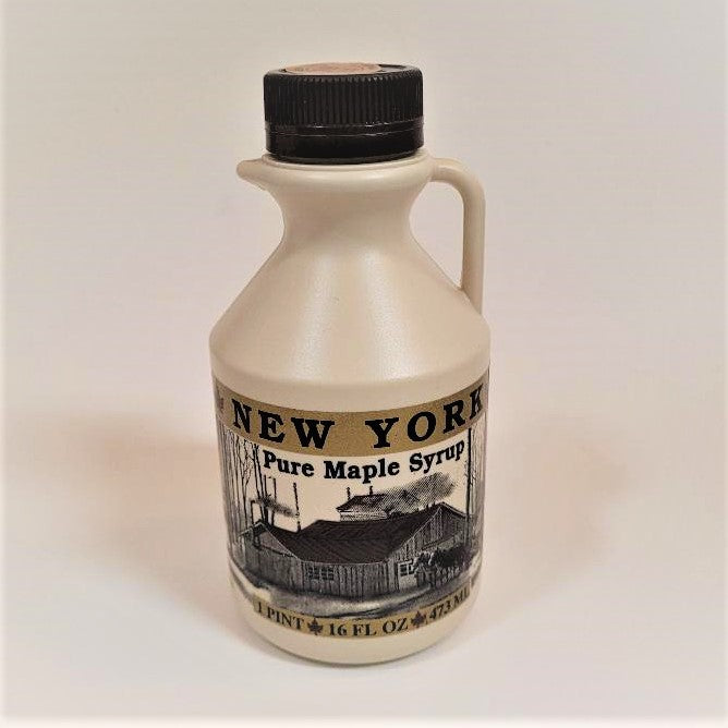 Pint-size plastic jug of maple syrup with black screw top and the label with the barn front and center standing with an -off-white background.
