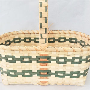 Woven market basket in neutral color with two rows of green trim weave showing on the front, the inside and the handle above the basket.
