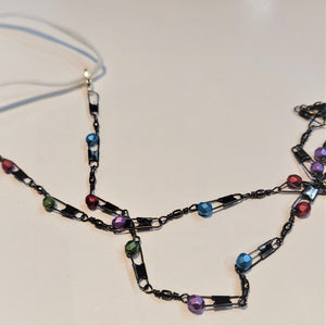Close up of the chain mask holder. Metal fishing lures with colored glass balls--green, red, blue and purple picture here.