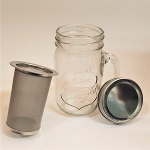 The empty mason jar glass is in the middle with the metal top to the right and the infuser standing to the left.