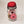 The jar itself with red-cushioned lid over the clear jar and the spools of white and pink thread that can be seen through the glass.