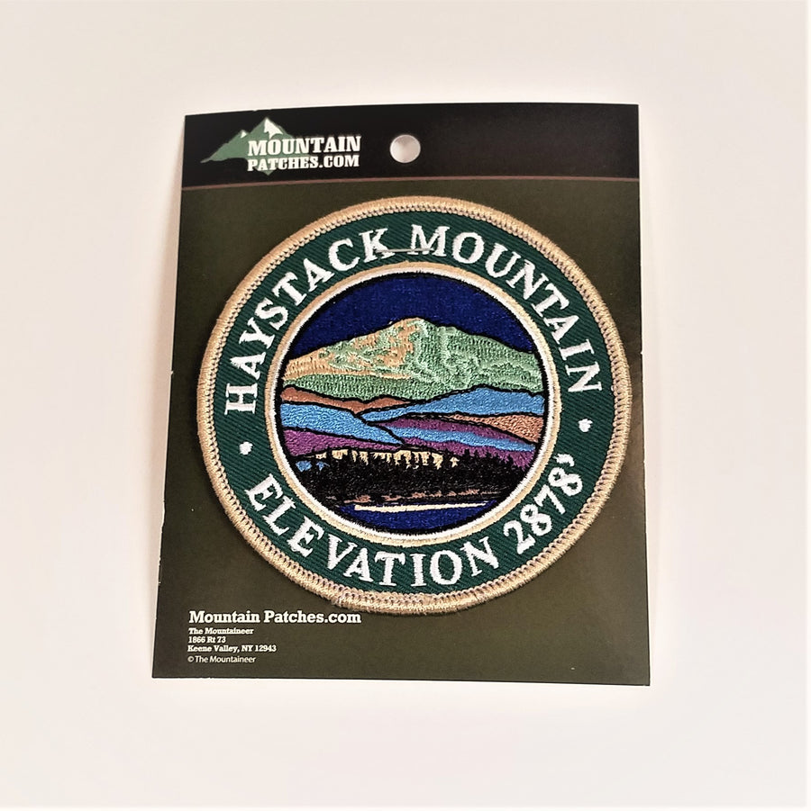 Single patch with a green circle border and white embroidered text reading HAYSTACK MOUNTAIN ELEVATION 2878 with mountain scene embroidered in circle in a circle.