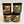 Four containers of different Adirondack peanut butters stacked one atop the other. Two on the left are Raisin the Roof and Dashing Thru the Dough. The two on the right are Beat Me to the Crunch and Nach-You Mama's Peanut Butter.