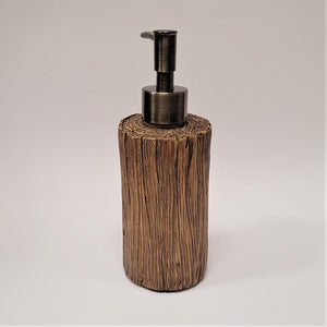 Back of the pine cone soap dispenser. Only the wood grain log-like cylinder is seen along with the back of the push spout.