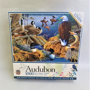 Audubon 1000 piece puzzle box cover featuring water birds on the water, above the water, on golden grassy perches in the water.