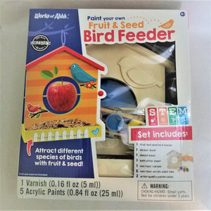 Boxed Fruit & Seed Bird Feeder set. Through the clear plastic panel can be seen part of the wooden frame, paint brushes and blue and yellow paint. The box features an image of what the completed project could look like along with specs on what is included.