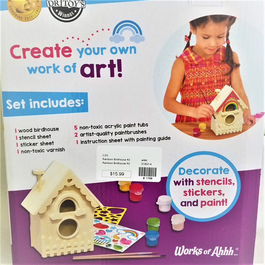 Back of the box of the paint your own birdhouse. Shows a young girl painting a wooden model, the wooden model by itself with decals and brushes near it, along with 6 little containers of paint: yellow, red, white, tan, green and blue.
