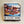 Box cover for 550 piece puzzle. Pictured are boats docked in water in front of an old-time resort with a gazebo to the right of the inn.