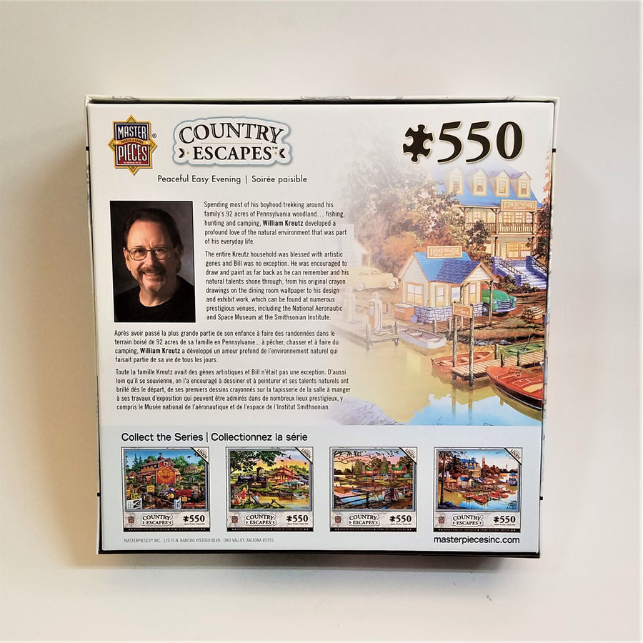 Back of the box of the 550 piece puzzle. The artist is pictured along with a faded picture of part of the puzzle and 4 miniature frames at the bottom with 4 puzzles in this series of 550 piece puzzles.