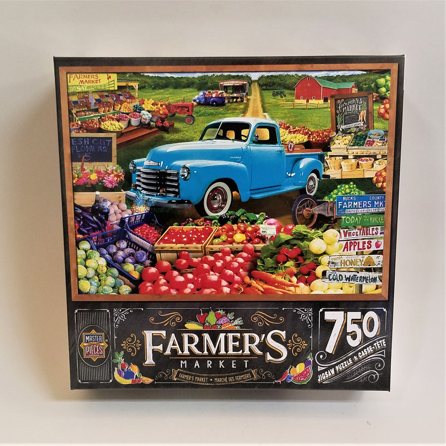 Colorful cover of Farmer's Market 750-piece jigsaw puzzle featuring baskets of bright colored vegetables, a blue truck and a red barn in a green field.