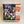 Box cover of 1000-piece Furry Friends (feline) puzzle. Ten cats in various positions look out along with a couple of butterflies. Black and white, beiges, gold, grays on a green lawn under some and some resting on bluish white steps.