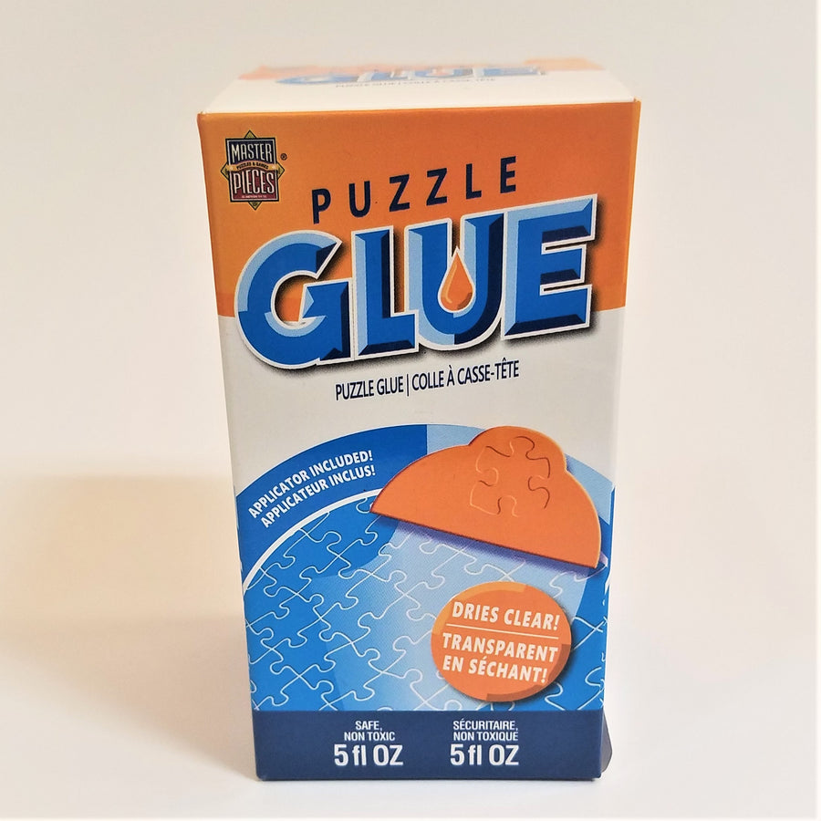 Box of Puzzle Glue standing upright. Blue lettering on orange and white background with an illustration of a blue jigsaw puzzle beneath.