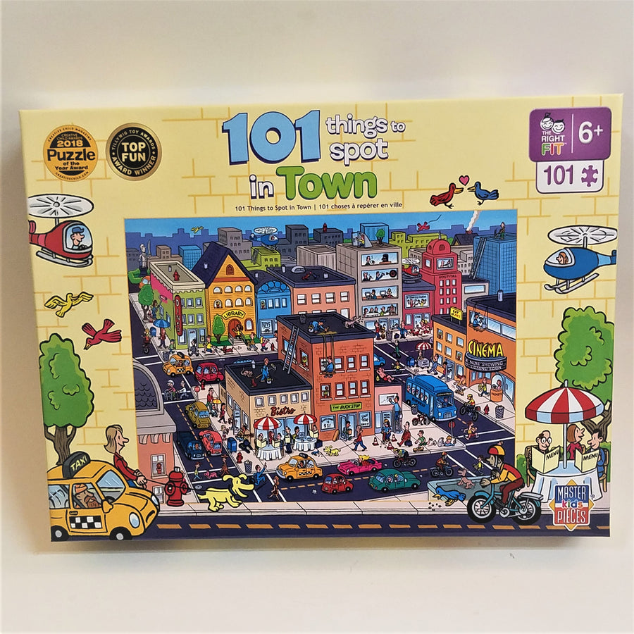 Puzzle box cover for 101 things to spot in town with a pale yellow border and colorful buildings in city blocks with blacktop streets filled with colorful cars, buses, bikes and people.