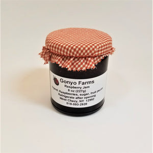 ColorRed-checkered cloth banded to a jar of Gonyo Farms Raspberry Jam.
