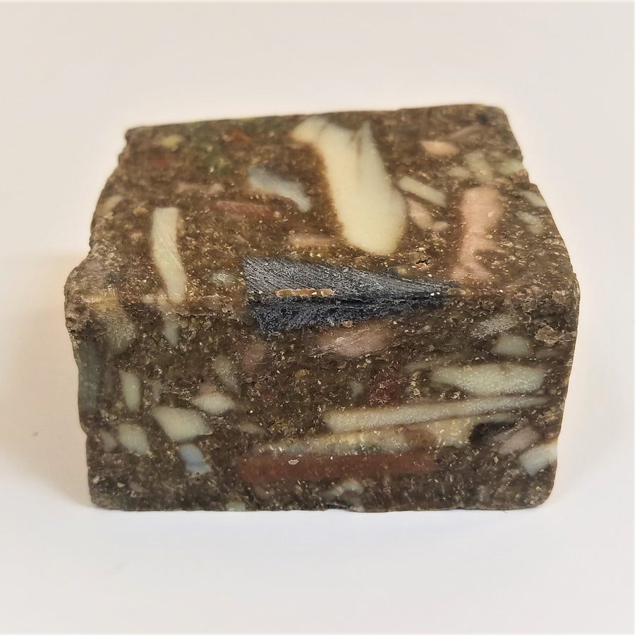 Brown soap square with lots of off-white and dark marble-like shaping on top and front side.