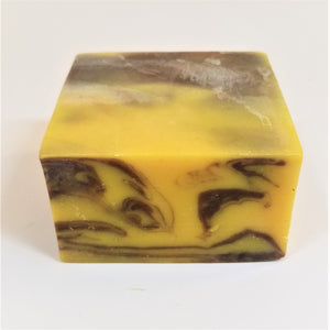 Yellow square soap bar with brown marble front side; top third yellow, back third shades of brown.
