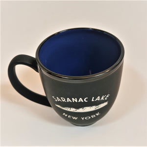 Black bistro mug seen from above with blue interior prominent over the white lettered graphic of the black front of the mug