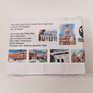 Back side of Saranac Lake note card set from Maria DeAngelo. Pictured in thumbnails are illustrations of the Clock Tower at Harrietstown Town Hall, the Saranac Lake Post Office, Hotel Saranac, the Adirondack Carousel, Mountain Mist Ice Cream Stand and Historic Saranac Lake.