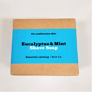 Eucalyptus and mint shave soap flat in its natural wrapping with sky-blue-colored label in center.