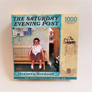 Box cover of the 1000 piece jigsaw puzzle featuring Norman Rockwell's Saturday Evening Post cover: The Shiner. Illustration of a girl in white shirt, plaid skirt with a black eye sitting on a bench outside the Principal's Office.